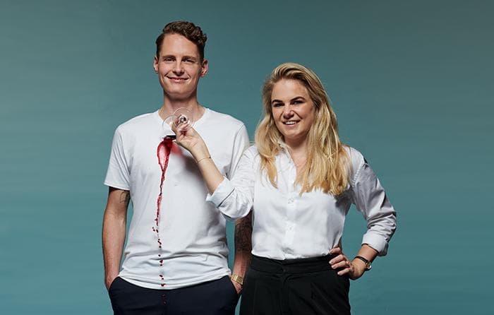 Man and woman spilling red wine on white shirt